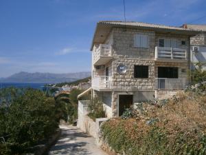 a house on the side of a hill next to the ocean at Apartments Maria in Povlja