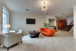 a living room with an orange couch and a tv at The Mantissa Hotel in Hartsville