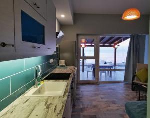 a kitchen with a sink and a view of the ocean at Pillbox Seafront Studios and Apartments in Kardamaina