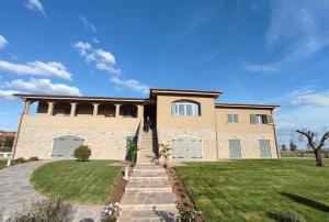 a large brick house with a grass yard at Sogni d'orto in Castiglione della Pescaia