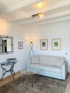 un soggiorno con divano bianco e tavolo di Art Hotel Ristorante Posta Al Lago a Ronco sopra Ascona