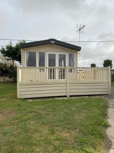 a small house with a fence in a yard at Sunningdale Sanctuary in Jaywick Sands