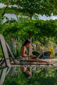 Eine Frau, die auf einem Stuhl mit einem Laptop sitzt. in der Unterkunft Uvita Paradise in Uvita