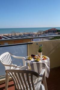 una mesa y sillas en un balcón con vistas al océano en Hotel Oceanic, en Rímini