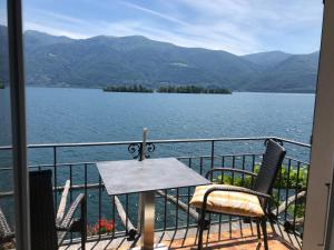 ロンコ・ソプラ・アスコナにあるArt Hotel Ristorante Posta Al Lagoの湖の景色を望むバルコニー(テーブル、椅子付)