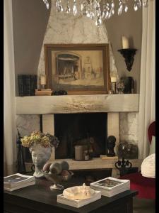 a living room with a fireplace with a picture above it at Il Pioppo Antico in Viggiù