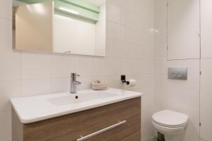 Un baño blanco con lavabo e inodoro. en Kloveniers Studio, en Ámsterdam 12 fotos más