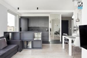 a kitchen and living room with a couch and a table at MS Apartments Green Hill II in Gdynia