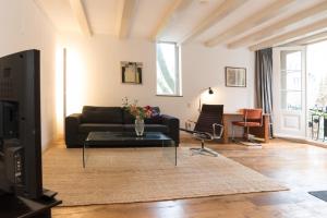 Una sala de estar con un sofá y una mesa de cristal. en Kloveniers Studio, en Ámsterdam