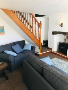 a living room with a couch and a staircase at New for 2021 Welcome to Violet Cottage in Combe Martin
