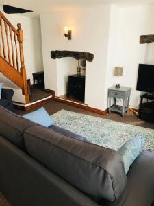 a living room with a couch and a television at New for 2021 Welcome to Violet Cottage in Combe Martin