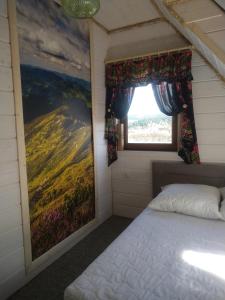 una camera da letto con un letto e una finestra di LEŚNY DWOREK 2 a Wołkowyja