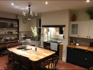 una cucina con tavolo in legno e alcune sedie di The Hollies a South Kilworth