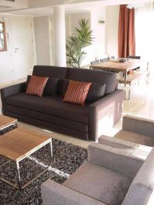 ein Wohnzimmer mit einem schwarzen Sofa und einem Tisch in der Unterkunft Villa in Spain at Las Colinas Golf & Country Club in Orihuela