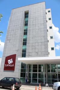 a building with a car parked in front of it at Tupyguá Brasil Hotel in Pedro Leopoldo