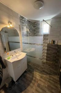 a bathroom with a sink and a shower at Rózsa Vendégház in Abádszalók