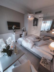 een grote witte slaapkamer met een groot bed en een tafel bij Dune B Mielno Exclusive in Mielno