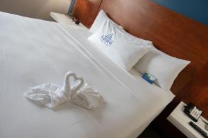 una habitación de hotel con dos cisnes sentados en una cama en The Azure Hotel en Mesa