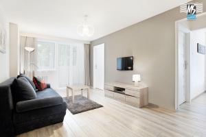 - un salon avec un canapé et une télévision dans l'établissement MS Apartments Antica, à Gdynia