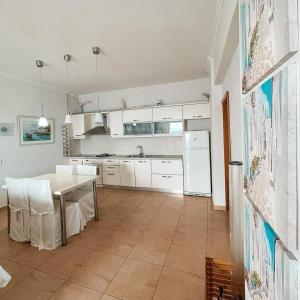 a kitchen with a table and a kitchen with white appliances at Villa Lori in Qeparo