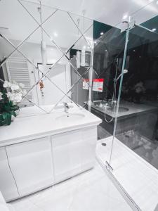 een badkamer met een witte wastafel en een spiegel bij Dune B Mielno Exclusive in Mielno
