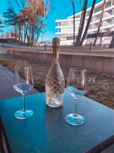 twee wijnglazen en een fles op tafel bij Dune B Mielno Exclusive in Mielno