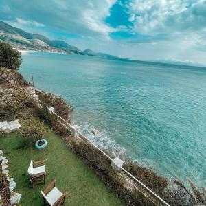 an aerial view of the ocean with two chairs at Villa Lori in Qeparo