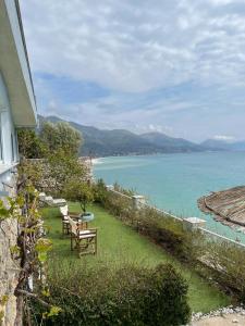 a house with two chairs and a table next to the water at Villa Lori in Qeparo +44 photos