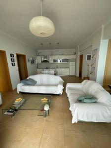 Cette grande chambre comprend deux lits et une table. dans l'établissement Villa Lori, à Qeparo