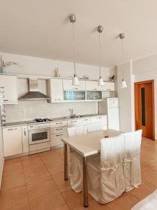 a kitchen with white cabinets and a table and chairs at Villa Lori in Qeparo