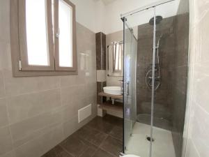 y baño con ducha acristalada y lavamanos. en Cattleya Holidays Apartment, en Porto Cesareo