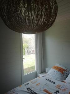 1 dormitorio con cama y ventana en Au cœur du jardin, en La Boussac
