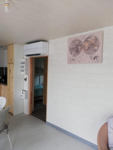 una habitación con una pared blanca con una foto en la pared en Au cœur du jardin, en La Boussac