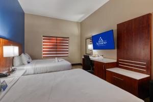 a hotel room with two beds and a desk at The Azure Hotel in Mesa