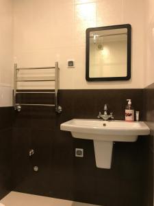 a bathroom with a white sink and a mirror at Guest house Forest in Pyatigorsk