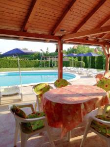 a table and chairs in front of a swimming pool at Apartment Gyenesdias 17 in Gyenesdiás