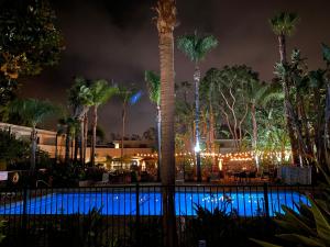 una piscina por la noche con palmeras y luces en Lemon Tree Inn en Santa Bárbara