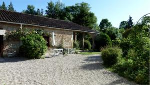 un cottage con tavolo e sedie di fronte di La Cascade de Hauterive a Pinel-Hauterive