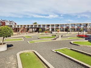 un patio con un edificio con un puente y césped en 5 person holiday home on a holiday park in Glesborg, en Glesborg