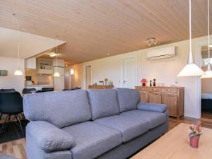 ein Wohnzimmer mit einem blauen Sofa und einer Küche in der Unterkunft Holiday home Humble XXVIII in Humble