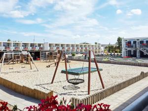 a playground with a swing set in the sand at 6 person holiday home on a holiday park in Glesborg in Glesborg