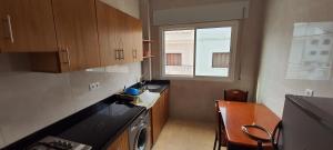 a small kitchen with a table and a window at El balcón del mediterráneo in M'diq