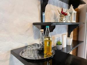 uma prateleira com uma garrafa e óculos em Vila Sofia em Predeal