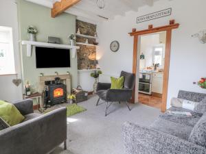 a living room with a fireplace and a tv at Town Head Cottage in Skipton