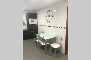 a kitchen with a table and chairs and a clock on the wall at Piso La Reina in Medina del Campo