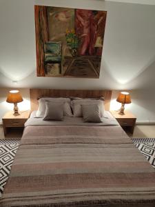 a bedroom with a large bed with two lamps at The traveller's nest in Nehoiu