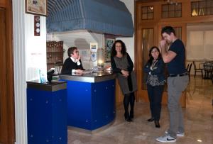 a group of people standing around a blue counter at Hotel Ave in Rimini