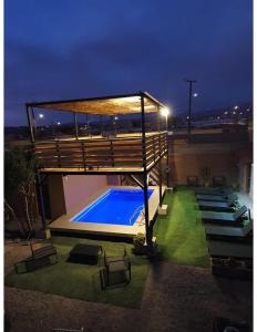 聖佩德羅·德·阿塔卡馬的住宿－Hostal Alto Yalí，一座游泳池,在晚上在一座建筑的顶部