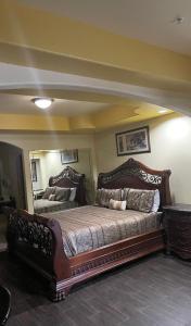 Raintree Inn and Suites في هيوستن: غرفة نوم بسرير كبير ومرآة كبيرة