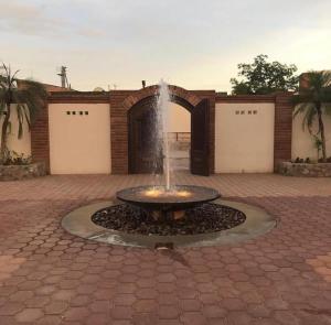 a fountain in front of a building with two garage doors at Hotel Andares de Kino by Rotamundos in Magdalena de Kino